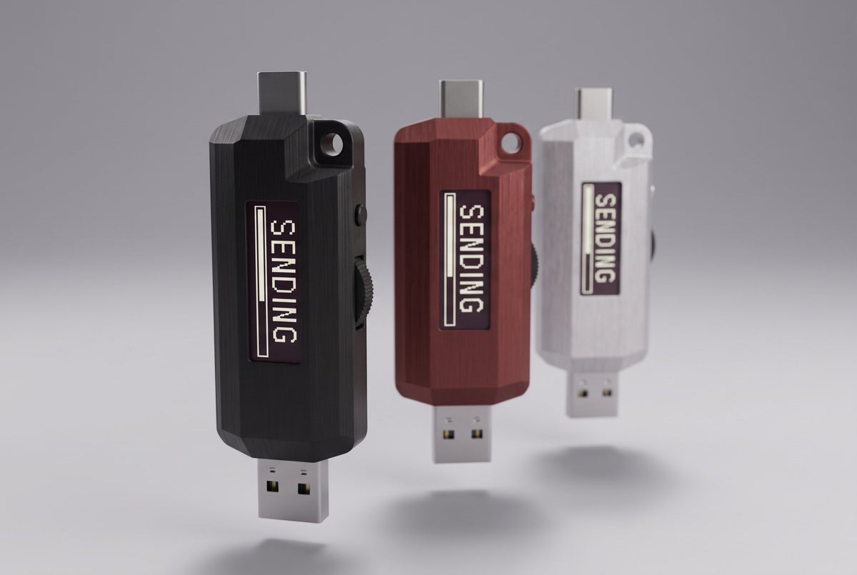 Three Lomenett password typers floating vertically (matte black, dried-blood red, and natural aluminum), each screen rotated to portrait showing SENDING, USB-A below and USB-C above